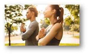 Young couple in yoga pose outdoors